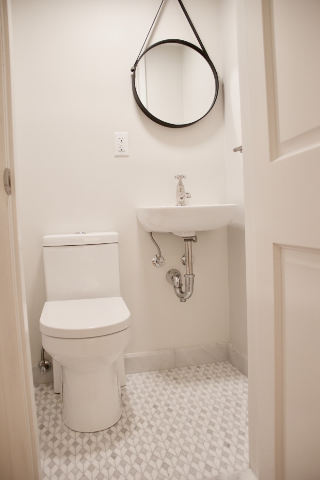 На фото: маленький туалет в стиле неоклассика (современная классика) с унитазом-моноблоком, белыми стенами, полом из мозаичной плитки, подвесной раковиной и серым полом для на участке и в саду
