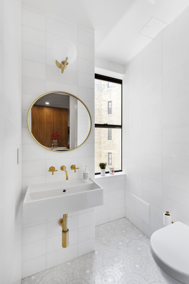 Стильный дизайн: туалет в современном стиле с инсталляцией, белой плиткой, керамической плиткой, полом из мозаичной плитки, подвесной раковиной и белым полом - последний тренд