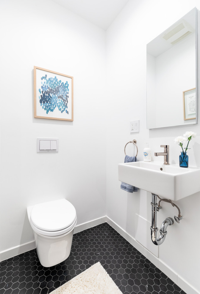 На фото: маленький туалет в стиле неоклассика (современная классика) с инсталляцией, белыми стенами, полом из керамической плитки, подвесной раковиной и черным полом для на участке и в саду