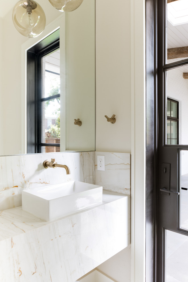 Cette photo montre un WC et toilettes chic avec du carrelage en marbre, une vasque, un plan de toilette en marbre, un carrelage beige, un mur beige et un plan de toilette beige.