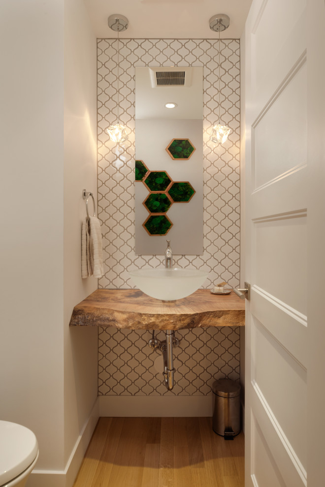 Exemple d'un petit WC et toilettes tendance avec un placard sans porte, WC à poser, un carrelage blanc, mosaïque, un mur blanc, parquet clair, une vasque et un plan de toilette en bois.