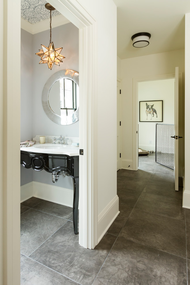 Cette image montre un WC et toilettes traditionnel de taille moyenne avec des portes de placard noires, un mur gris, un sol en carrelage de porcelaine, un lavabo encastré, un plan de toilette en marbre et un sol gris.