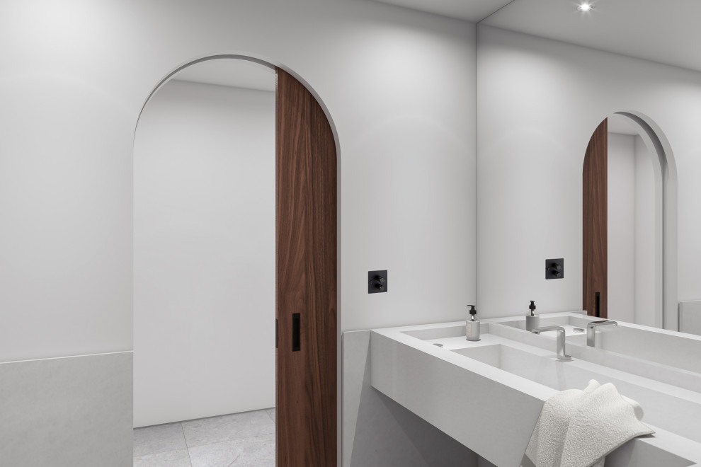 This is an example of an expansive world-inspired cloakroom with white cabinets, an urinal, white tiles, marble tiles, white walls, limestone flooring, an integrated sink, marble worktops, grey floors and white worktops.
