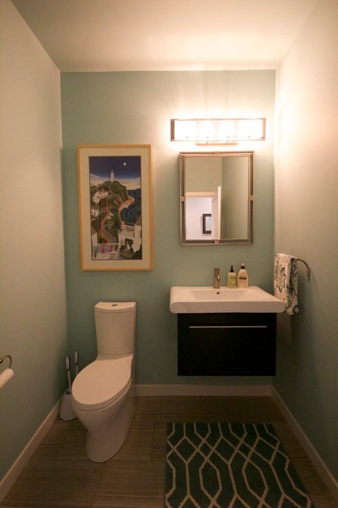 Пример оригинального дизайна: туалет среднего размера в стиле модернизм с монолитной раковиной, плоскими фасадами, темными деревянными фасадами, раздельным унитазом, серой плиткой, синими стенами и полом из керамической плитки