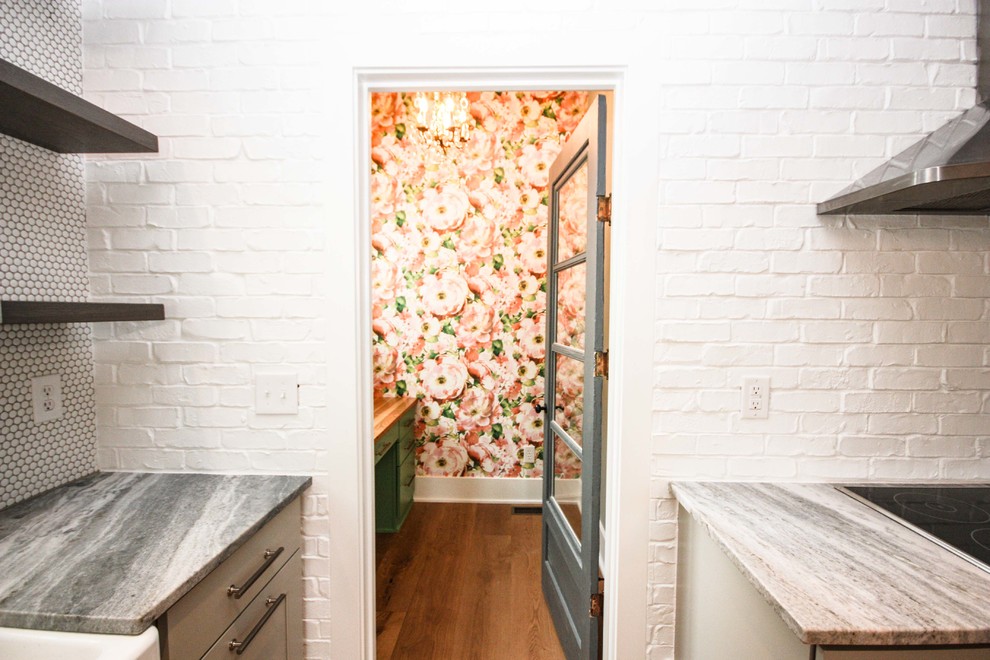 Cette photo montre un petit WC et toilettes nature avec un placard à porte plane, des portes de placards vertess, un carrelage rose, un mur rose, parquet foncé, un plan de toilette en bois et un sol marron.