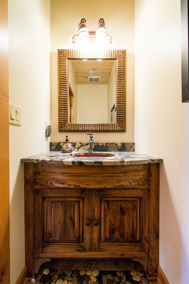 Idéer för att renovera ett litet rustikt toalett, med luckor med upphöjd panel, skåp i mörkt trä, beige väggar, klinkergolv i småsten, ett undermonterad handfat, granitbänkskiva och brunt golv