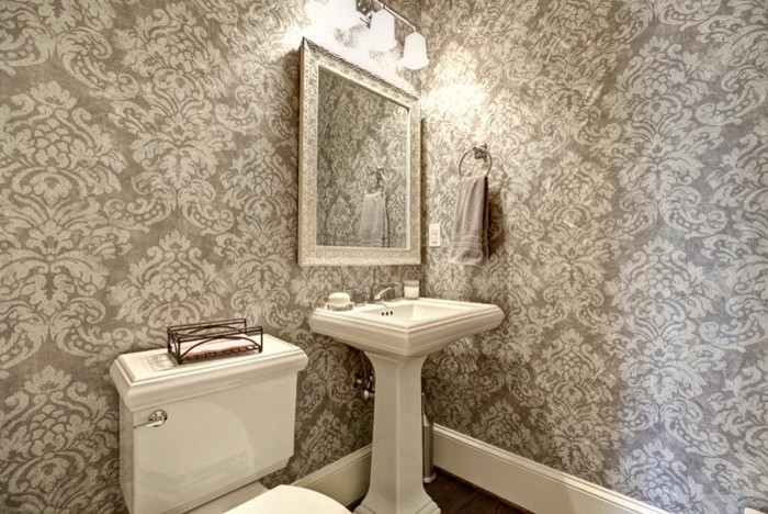Idéer för att renovera ett litet vintage toalett, med en toalettstol med separat cisternkåpa, grå väggar, mörkt trägolv, ett piedestal handfat och brunt golv