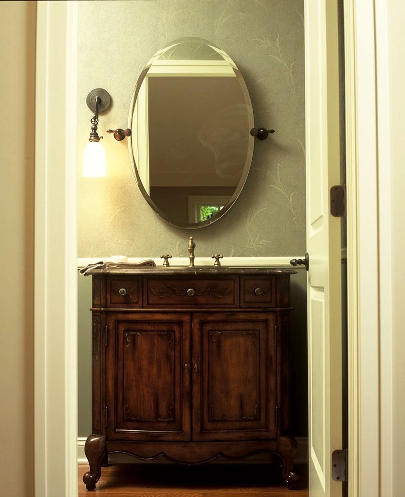 Idée de décoration pour un WC et toilettes tradition en bois foncé de taille moyenne avec un placard avec porte à panneau encastré, un sol en bois brun et un plan de toilette en stéatite.