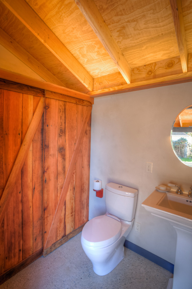 Idee per un bagno di servizio country di medie dimensioni con lavabo a colonna, WC a due pezzi, pareti beige e pavimento in cemento
