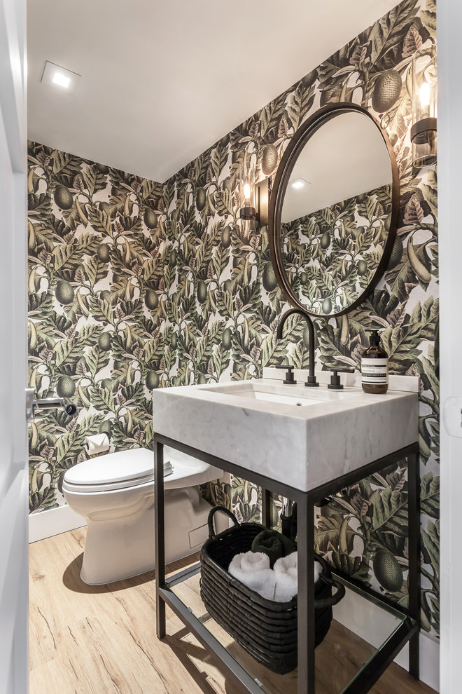 Small contemporary cloakroom in Miami with white cabinets, a one-piece toilet, green walls, laminate floors, beige floors, white worktops, open cabinets and a console sink.