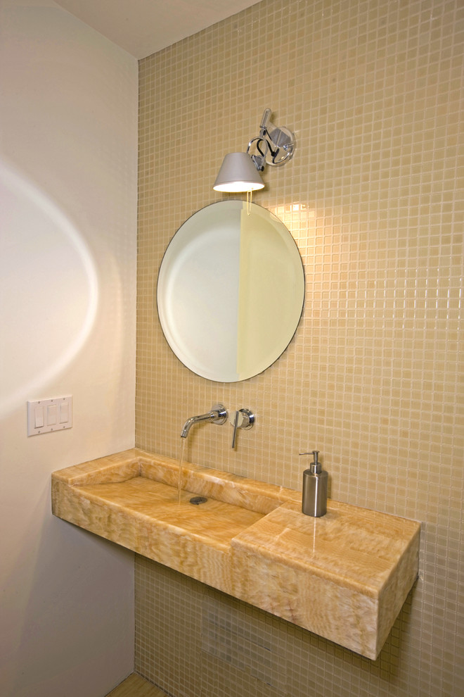 Foto på ett mellanstort funkis toalett, med gul kakel, ett integrerad handfat, bänkskiva i onyx och mosaik