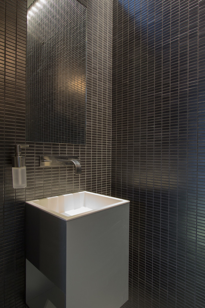 Idée de décoration pour un WC suspendu minimaliste avec un placard à porte plane, des portes de placard grises, un carrelage gris, mosaïque, un mur gris, sol en béton ciré, un lavabo suspendu et un sol gris.