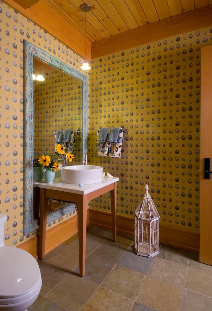 На фото: туалет среднего размера в стиле рустика с разноцветными стенами, настольной раковиной, темными деревянными фасадами, полом из керамогранита, столешницей из искусственного камня и разноцветным полом