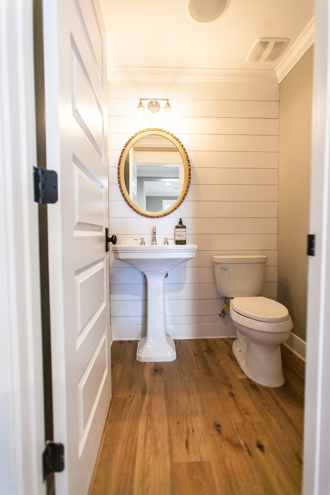 Esempio di un piccolo bagno di servizio country con WC a due pezzi, pareti grigie, pavimento in legno massello medio e lavabo a colonna