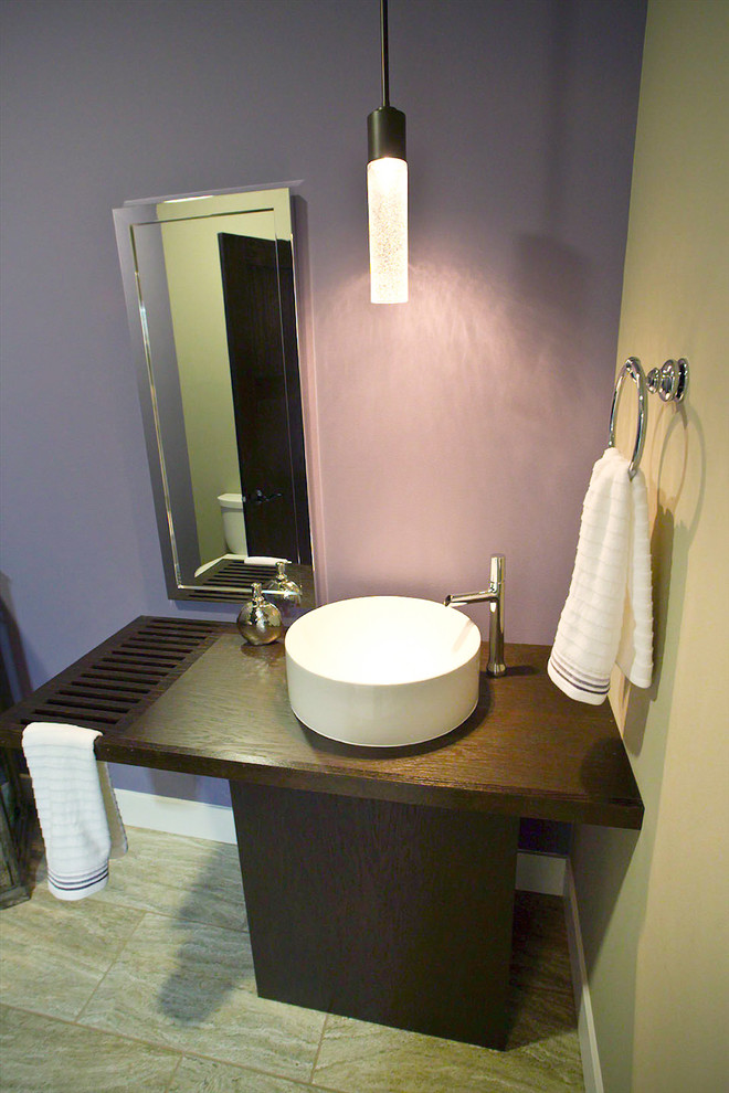 Diseño de aseo actual con lavabo sobreencimera, encimera de mármol, sanitario de una pieza y baldosas y/o azulejos beige