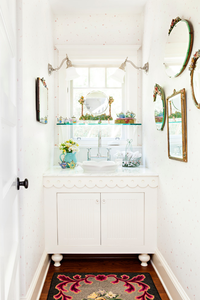 Kleine Shabby-Style Gästetoilette mit weißen Schränken, braunem Holzboden, Aufsatzwaschbecken, Marmor-Waschbecken/Waschtisch, weißer Wandfarbe und Schrankfronten mit vertiefter Füllung in Los Angeles