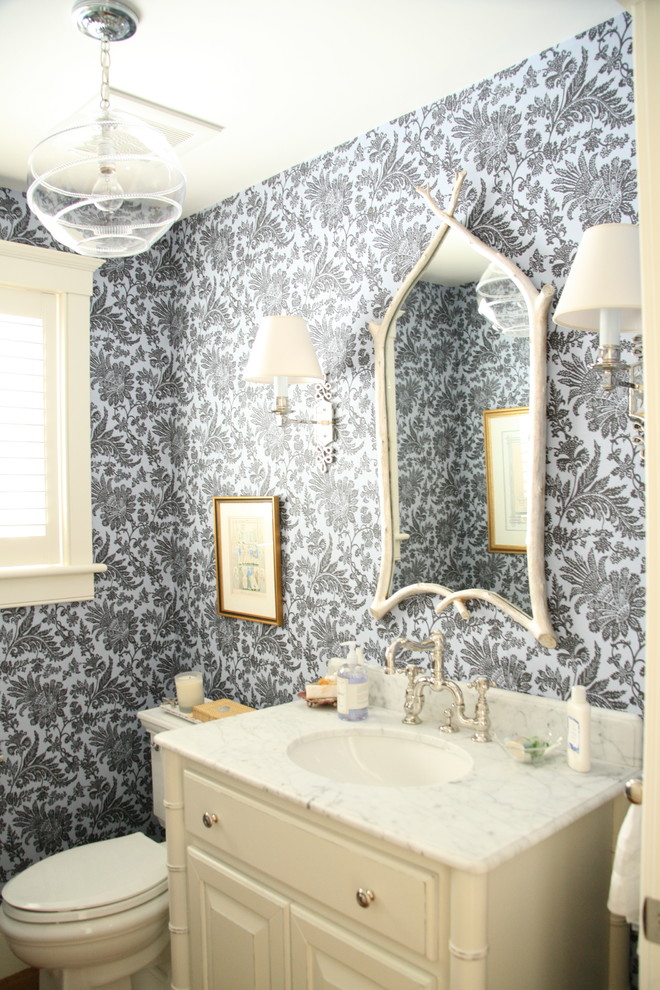 Inspiration for a timeless powder room remodel in Boston with an undermount sink, furniture-like cabinets, white cabinets, marble countertops and a two-piece toilet