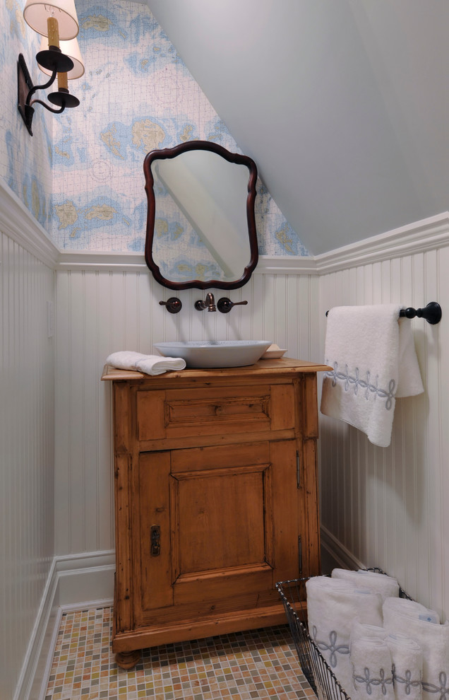 Inspiration for a small victorian cloakroom in New York with a vessel sink, medium wood cabinets, wooden worktops, mosaic tile flooring, recessed-panel cabinets and brown worktops.