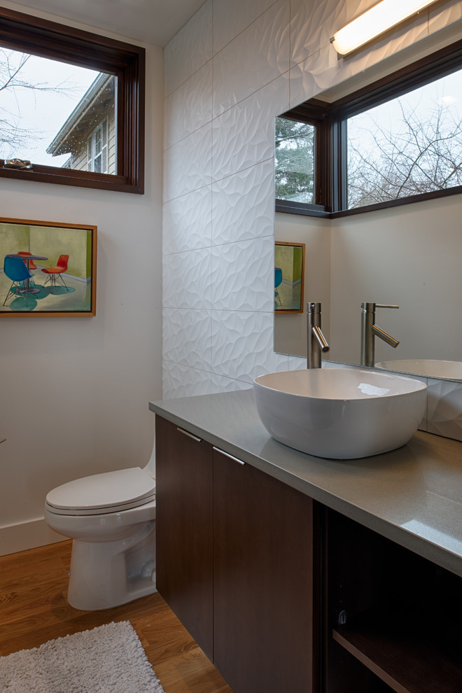 Cette photo montre un grand WC et toilettes tendance en bois foncé avec WC séparés, un carrelage blanc, des carreaux de céramique, un mur blanc, parquet foncé, une vasque et un plan de toilette en quartz modifié.