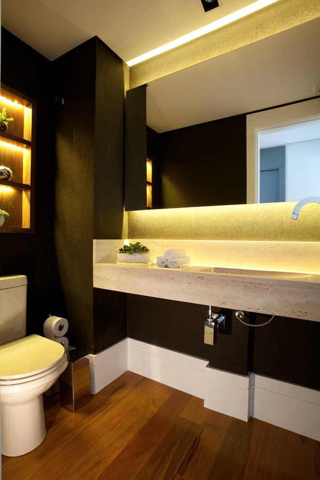 Diseño de aseo actual pequeño con paredes marrones, suelo de madera clara, lavabo integrado y encimera de travertino