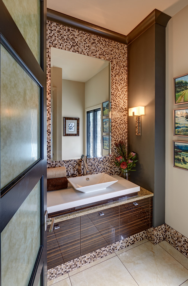 Idee per un bagno di servizio design con lavabo a bacinella, ante lisce, ante in legno bruno, piastrelle marroni, piastrelle a mosaico, pareti beige e top bianco