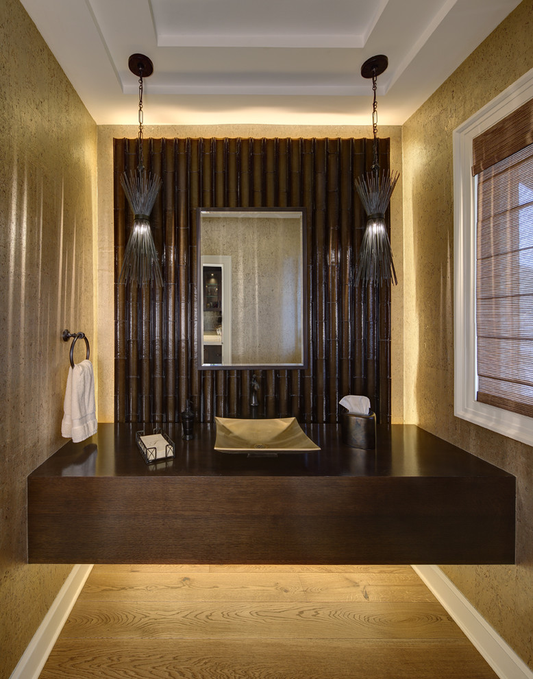 Modelo de aseo contemporáneo con paredes beige, suelo de madera clara y lavabo sobreencimera