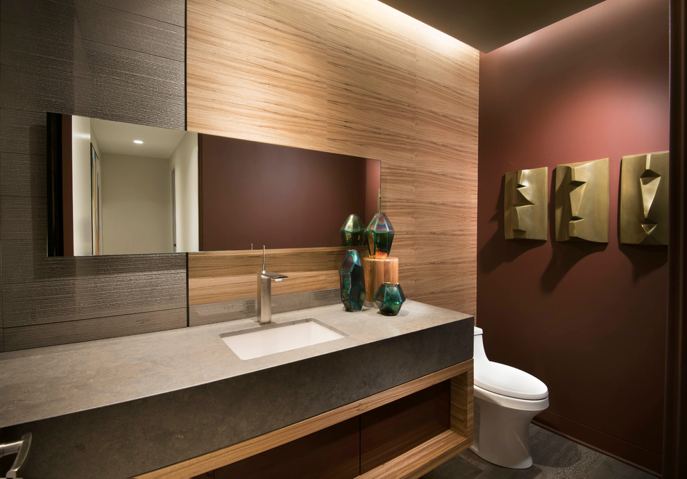 Aménagement d'un WC et toilettes contemporain avec WC à poser, un mur marron, un lavabo encastré et un plan de toilette gris.