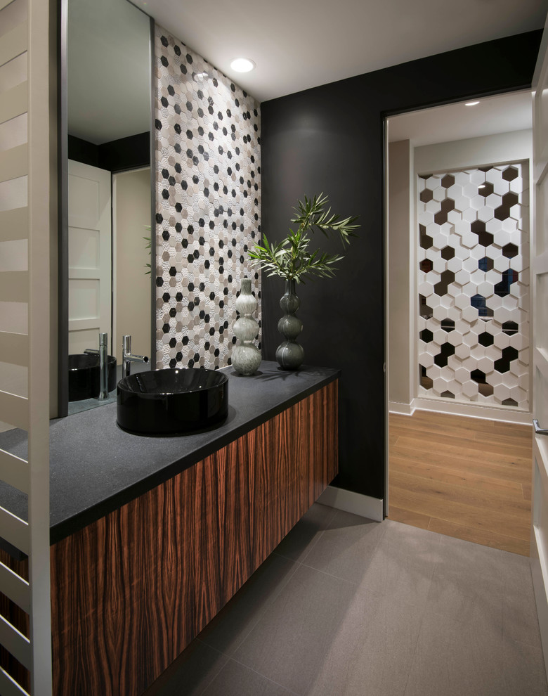 Trendy gray floor powder room photo in Phoenix with medium tone wood cabinets, black walls, a vessel sink and black countertops