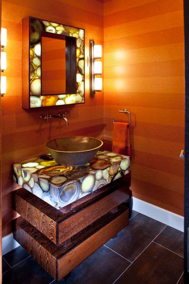 Идея дизайна: огромный туалет в современном стиле с фасадами островного типа, фасадами цвета дерева среднего тона, унитазом-моноблоком, оранжевыми стенами, полом из керамогранита, настольной раковиной, столешницей из оникса, разноцветным полом и разноцветной столешницей