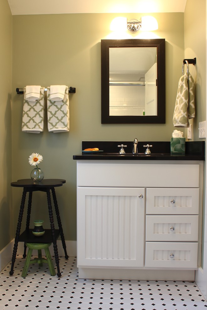 Foto på ett mellanstort lantligt toalett, med skåp i shakerstil, vita skåp, svart kakel, vit kakel, porslinskakel, gröna väggar, klinkergolv i porslin, ett undermonterad handfat och bänkskiva i akrylsten