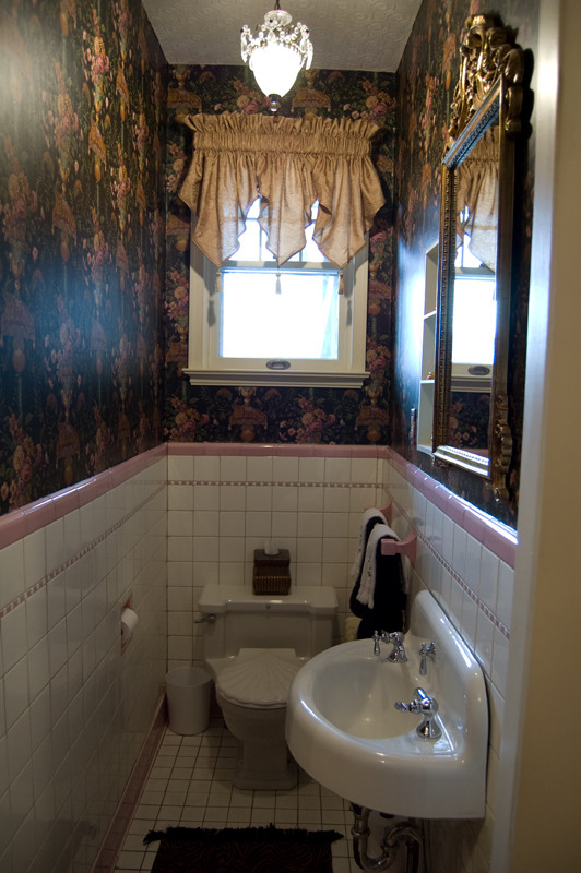 Foto di un piccolo bagno di servizio chic con WC monopezzo, piastrelle bianche, pareti multicolore, pavimento con piastrelle in ceramica e lavabo sospeso