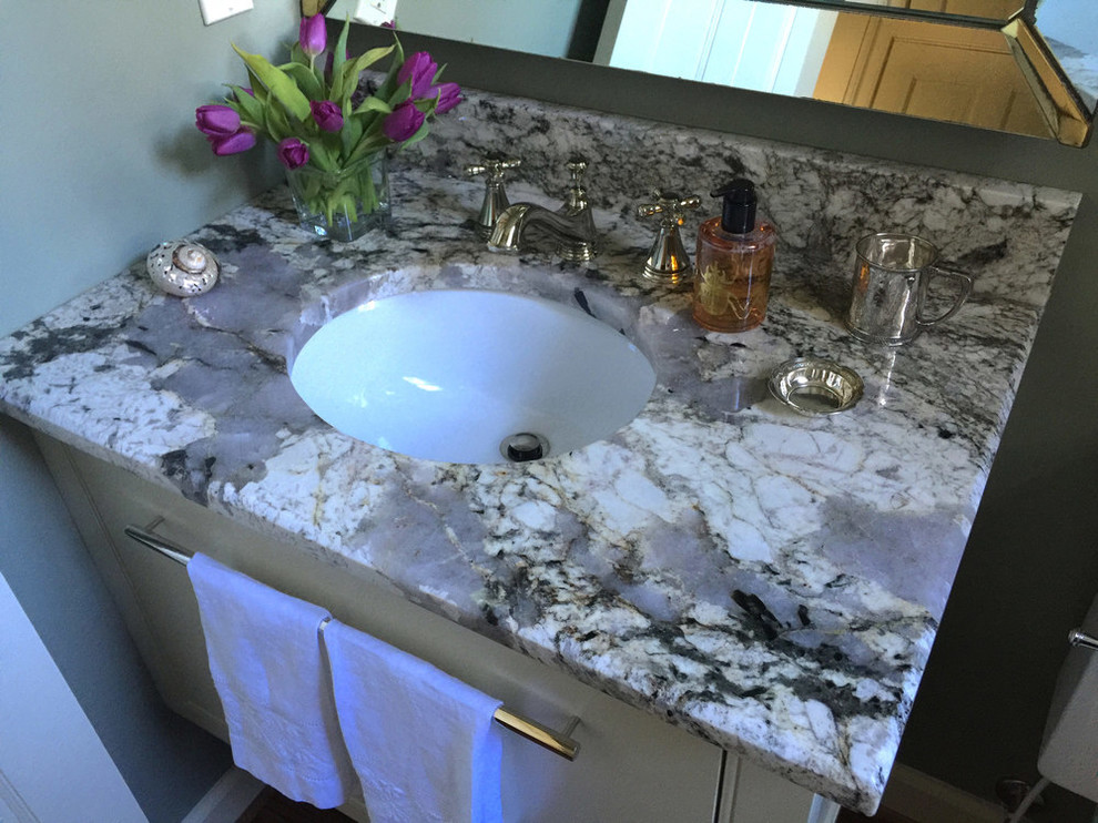 Mid-sized elegant powder room photo in San Diego with flat-panel cabinets, white cabinets, a one-piece toilet, blue walls, an undermount sink and granite countertops