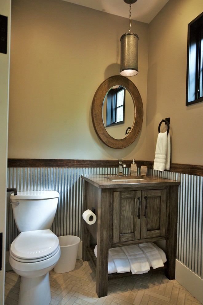 Foto di un bagno di servizio country di medie dimensioni con ante in stile shaker, ante in legno scuro, WC monopezzo, pareti marroni, lavabo sottopiano, top in legno e top marrone