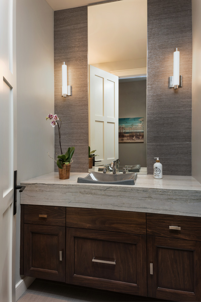 Photo of a medium sized classic cloakroom in San Diego with recessed-panel cabinets, dark wood cabinets, a one-piece toilet, grey tiles, porcelain tiles, grey walls, porcelain flooring, a vessel sink, marble worktops and grey floors.