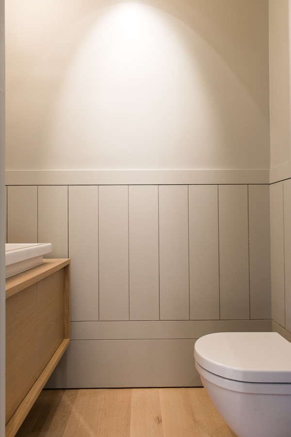 На фото: туалет среднего размера в современном стиле с плоскими фасадами, светлыми деревянными фасадами, инсталляцией, бежевыми стенами, светлым паркетным полом, накладной раковиной, столешницей из дерева и бежевым полом