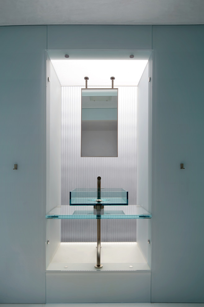Cette photo montre un WC et toilettes tendance avec une vasque et un plan de toilette en verre.