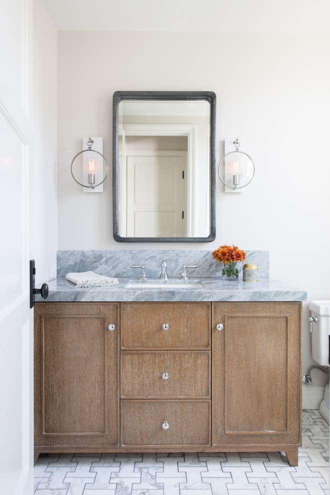 Inspiration for a mid-sized transitional marble floor and white floor powder room remodel in Los Angeles with furniture-like cabinets, medium tone wood cabinets, beige walls, an undermount sink, marble countertops and gray countertops