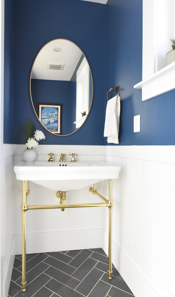 Example of a mid-sized arts and crafts gray floor and porcelain tile powder room design in Other with a one-piece toilet, blue walls and an integrated sink