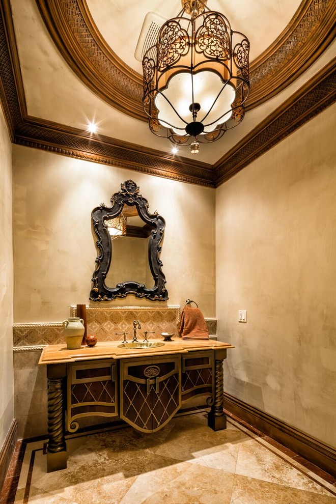 ロサンゼルスにある中くらいなトラディショナルスタイルのおしゃれなトイレ・洗面所 (家具調キャビネット、ベージュの壁、オーバーカウンターシンク、濃色木目調キャビネット、ベージュの床) の写真