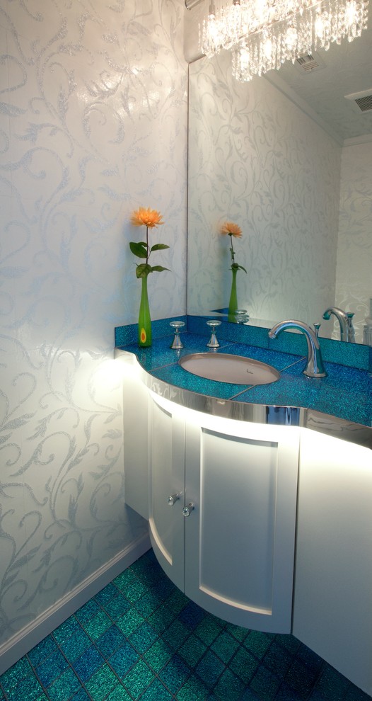 Foto på ett funkis turkos toalett, med ett undermonterad handfat, skåp i shakerstil, vita skåp och blå väggar