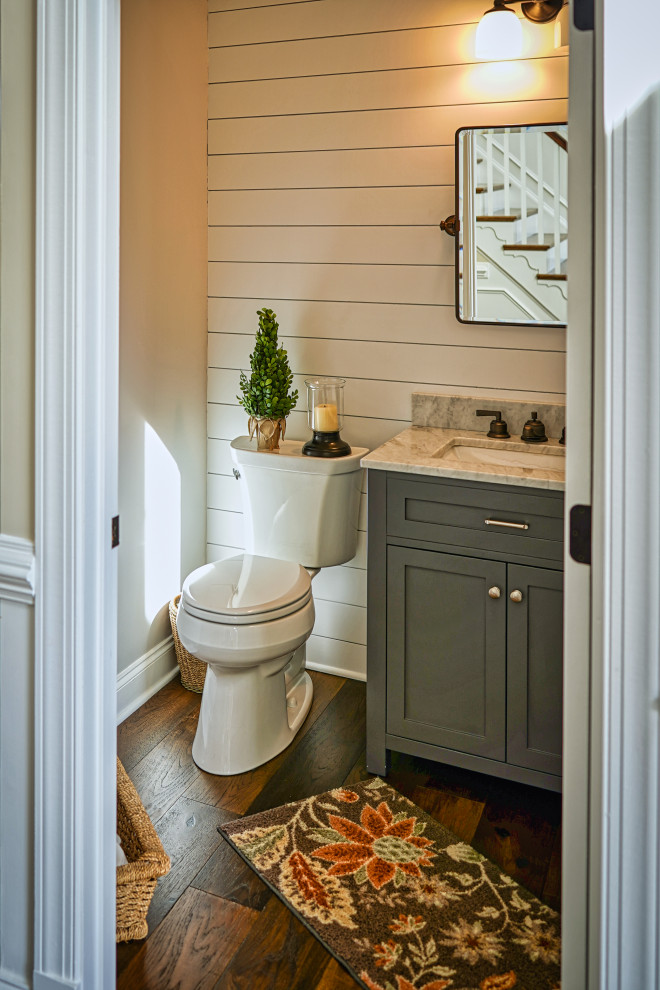Inspiration for a mid-sized transitional medium tone wood floor, brown floor and shiplap wall powder room remodel in DC Metro with shaker cabinets, gray cabinets, a two-piece toilet, gray walls, an undermount sink, granite countertops, brown countertops and a freestanding vanity