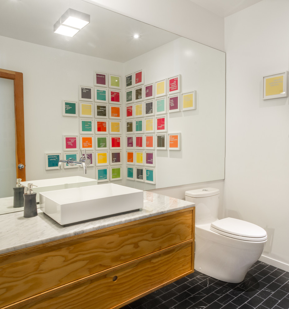 Esempio di un bagno di servizio moderno di medie dimensioni con ante lisce, ante in legno chiaro, WC monopezzo, pareti bianche, lavabo a bacinella e top in marmo