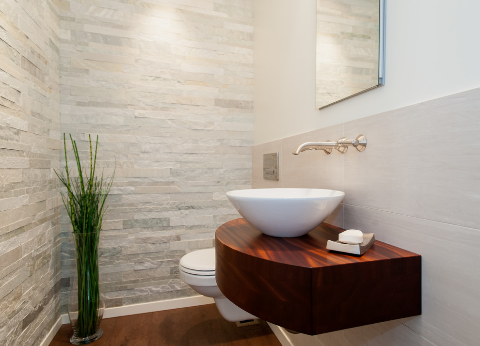 Idee per un piccolo bagno di servizio design con WC sospeso, piastrelle bianche, pareti bianche, pavimento in legno massello medio, lavabo a bacinella, top in legno e top marrone