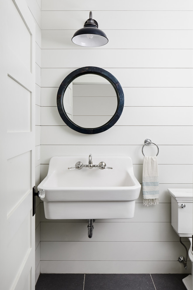 Cette image montre un petit WC et toilettes rustique avec WC séparés, un mur blanc, un sol en ardoise, un lavabo suspendu et un sol gris.
