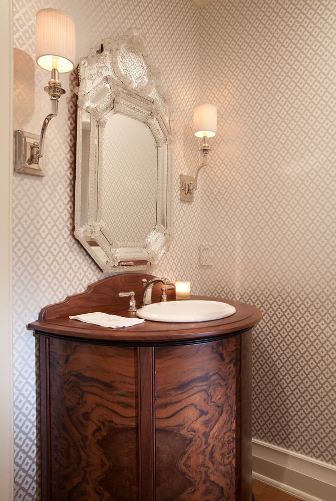 Immagine di un bagno di servizio classico con lavabo da incasso, consolle stile comò, ante in legno bruno, pareti multicolore, top in legno e top marrone
