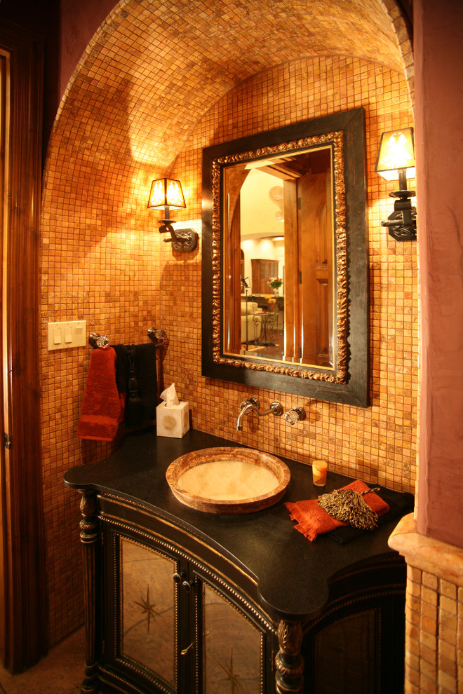 Réalisation d'un grand WC et toilettes méditerranéen avec un placard en trompe-l'oeil, des portes de placard noires, mosaïque, un mur marron, une vasque, un plan de toilette en bois et un carrelage orange.