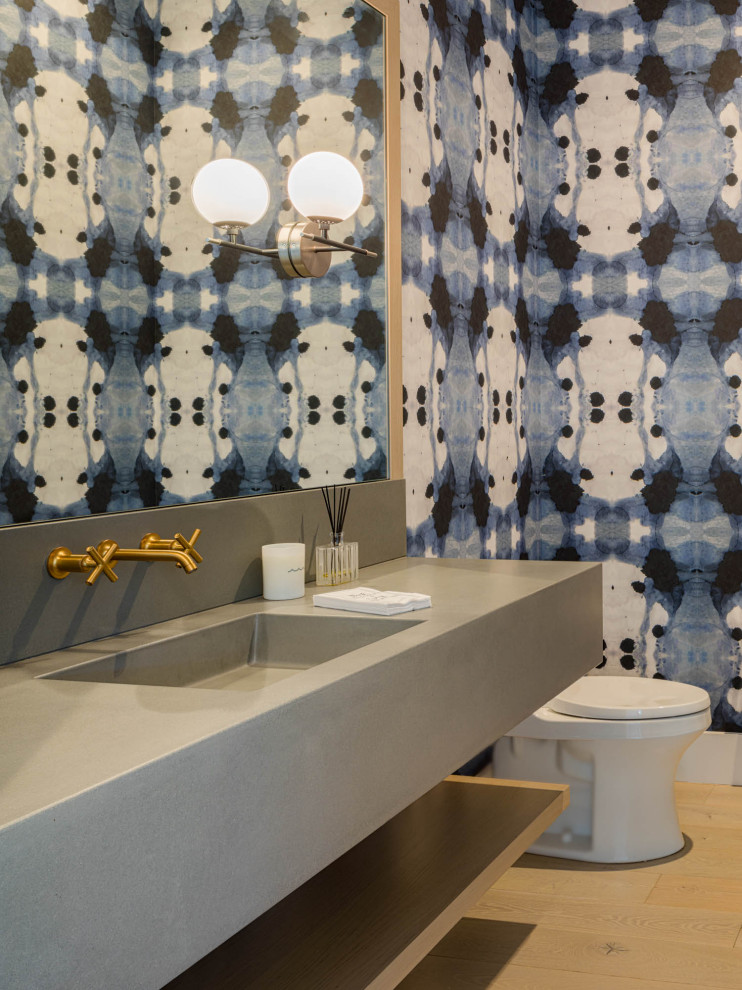 This is an example of a nautical cloakroom in Seattle with open cabinets, grey cabinets, a one-piece toilet, multi-coloured tiles, multi-coloured walls, light hardwood flooring, an integrated sink, grey worktops, a floating vanity unit and wallpapered walls.