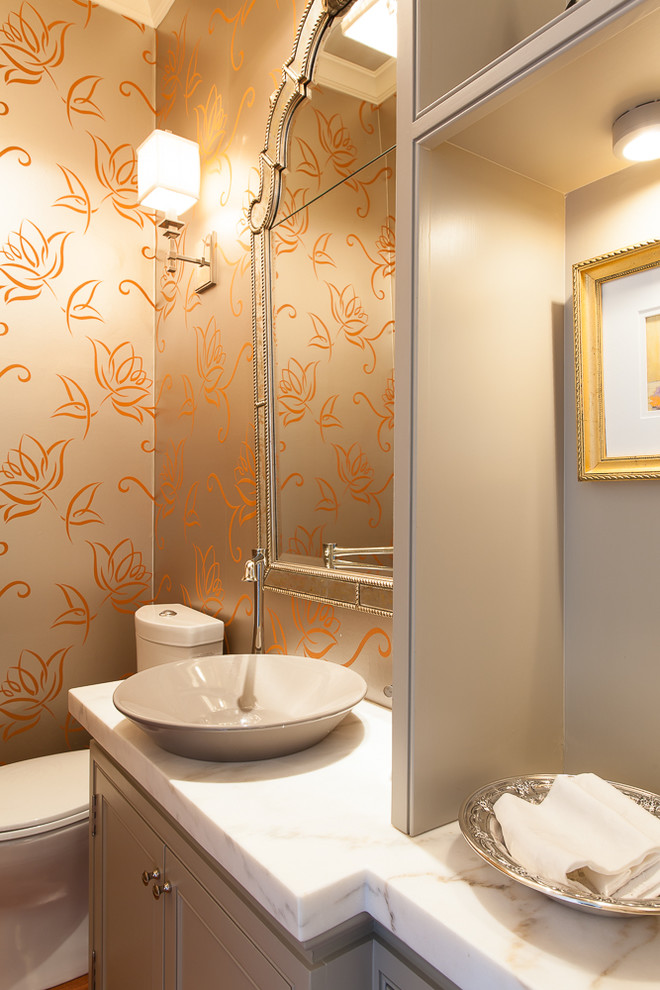 Inspiration för små moderna toaletter, med ett fristående handfat, luckor med profilerade fronter, grå skåp, marmorbänkskiva, en toalettstol med separat cisternkåpa, orange väggar och mellanmörkt trägolv