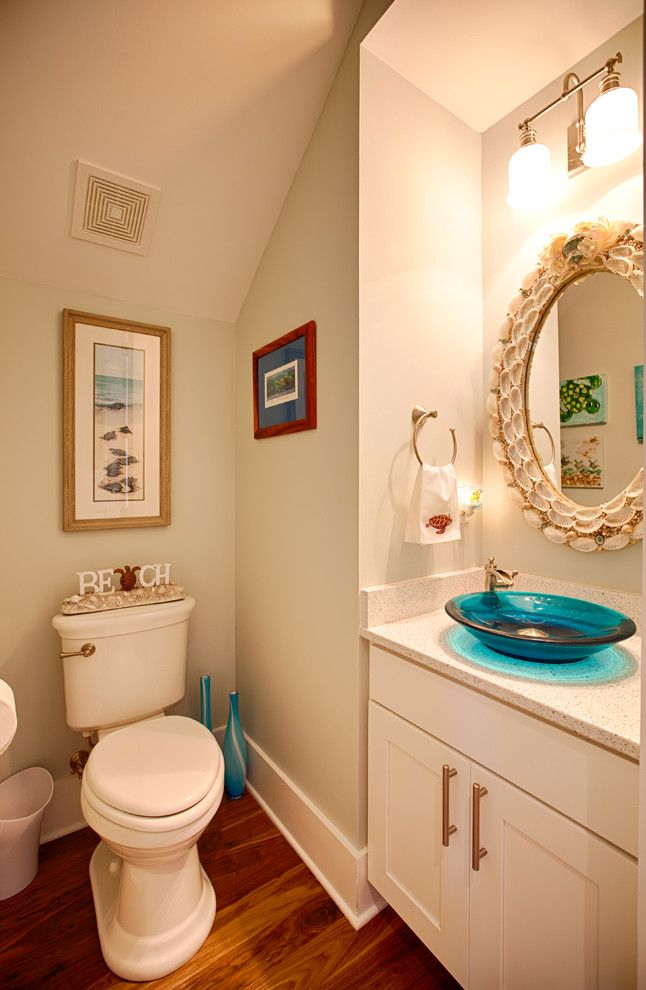 Inspiration for a small coastal medium tone wood floor and brown floor powder room remodel in Miami with shaker cabinets, white cabinets, a two-piece toilet, beige walls, a vessel sink, quartz countertops and beige countertops