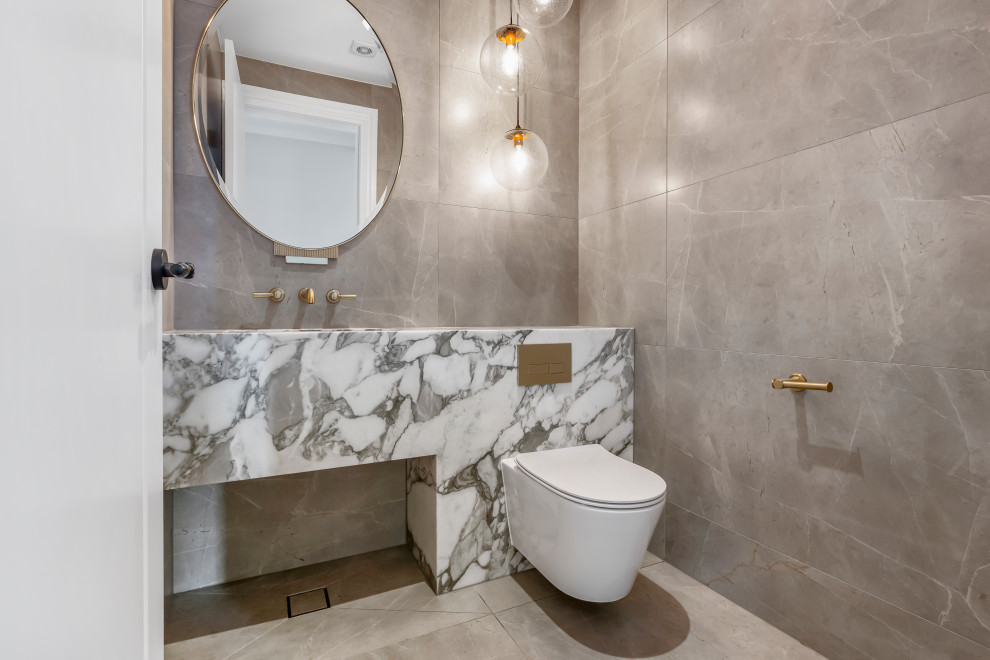 Contemporary powder room in Sydney with flat-panel cabinets, a wall-mount toilet, gray tile, white tile, an integrated sink, beige floor and a built-in vanity.